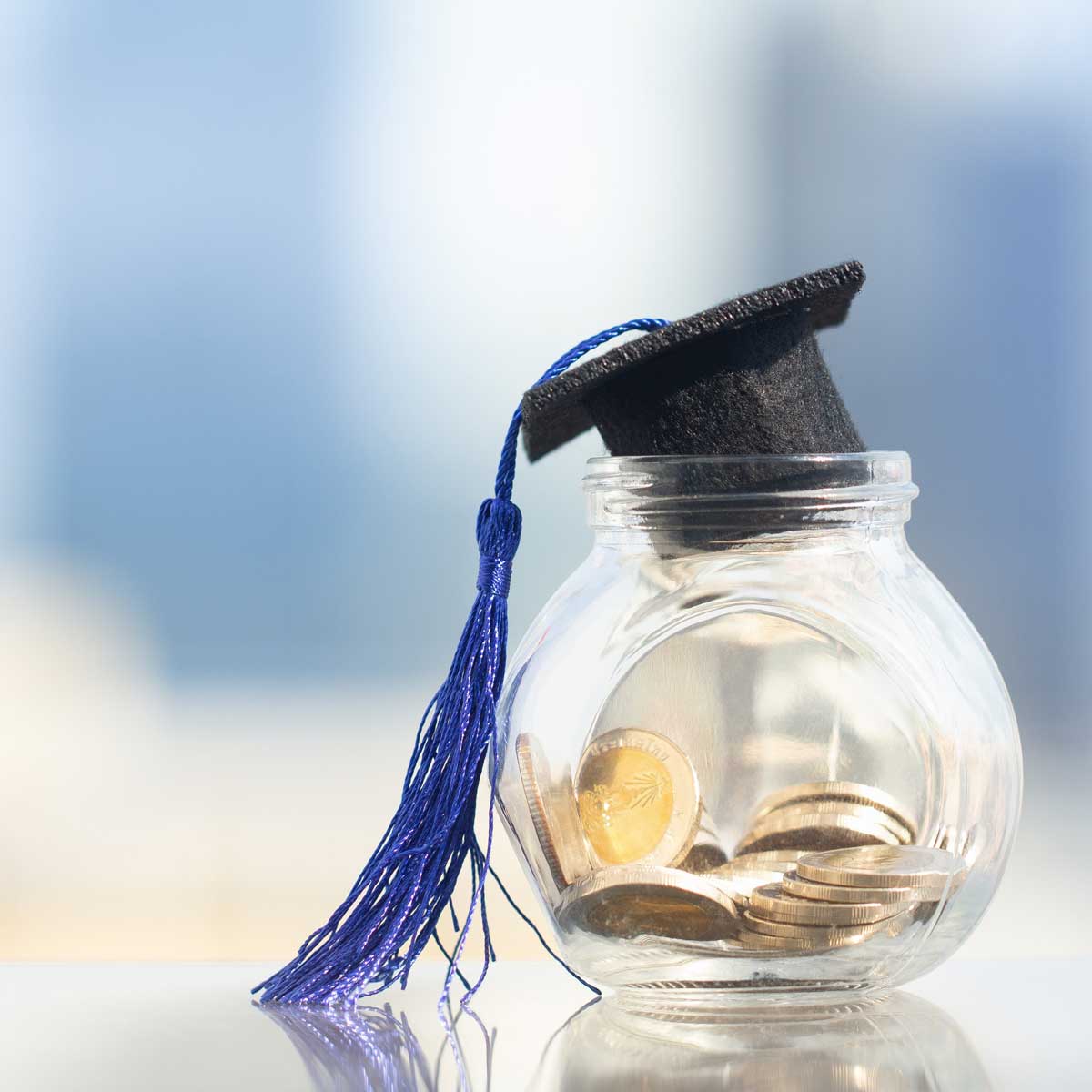 money in a jar with a graduation cap on top