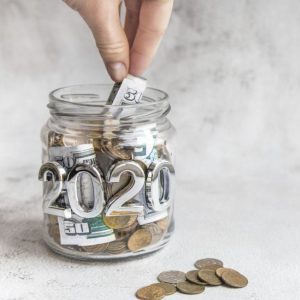 Budget 2020. Glass jar with money, coins and notes, savings, loans and mortgages