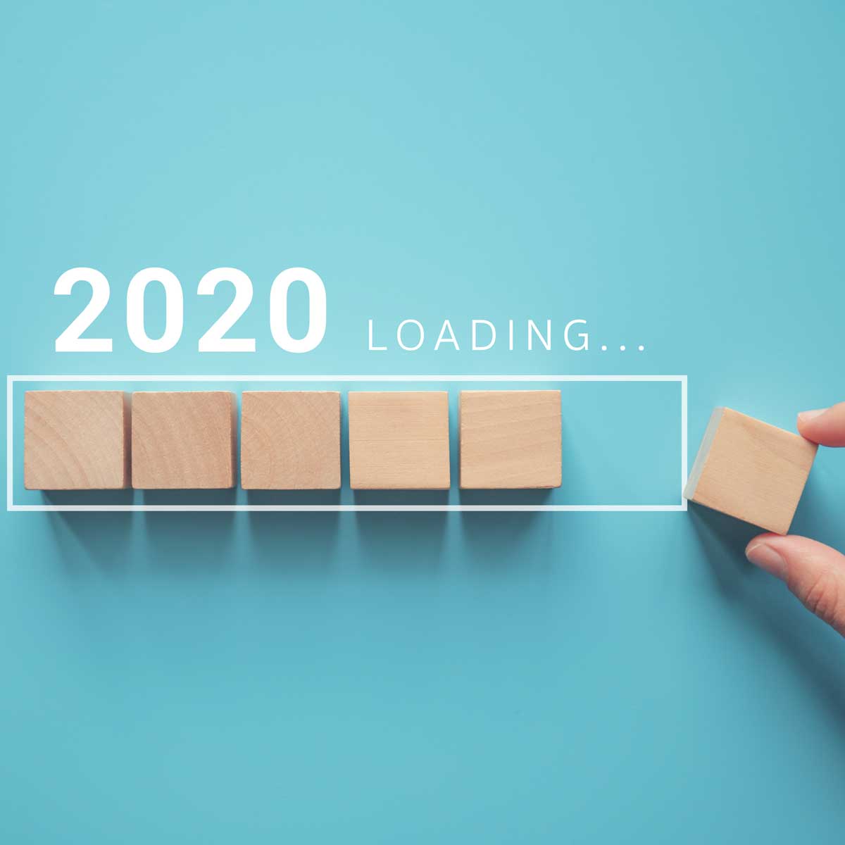Loading new year 2020 with hand putting wood cube in progress bar.