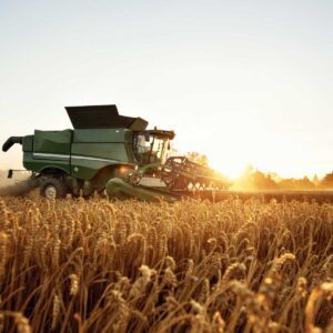 feed-and-grain-agriculture-industry-technology; tractor pictured among grain field in sunset