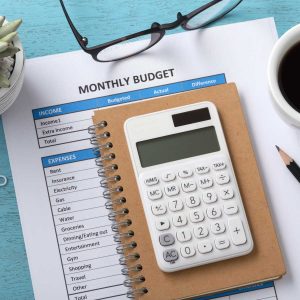 Monthly budget with white calculator on blue table