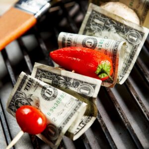 grilling and bbq concept; grilling skewer with tomato, pepper and dollar bills on the stick