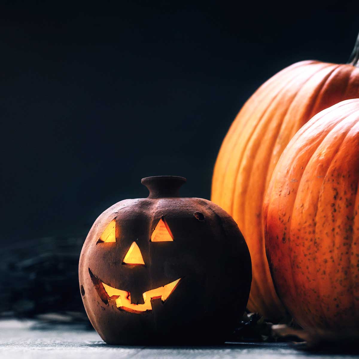 Jack o Lantern - autumn Halloween holiday concept background; black background with pumpkins and a jack o lantern