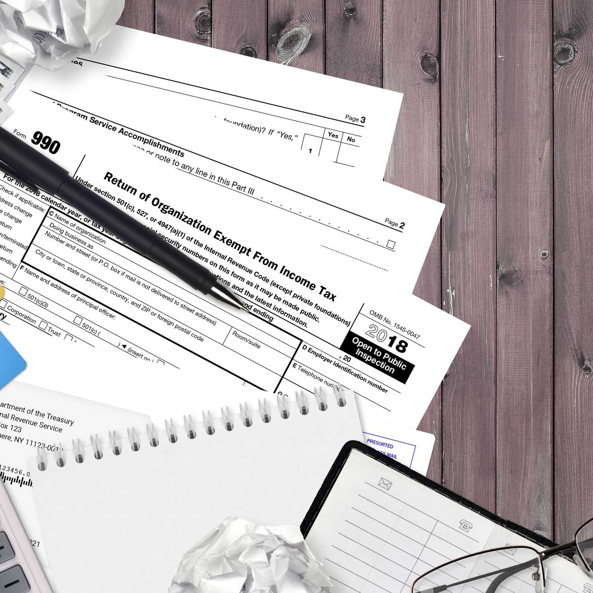 IRS form 990 Return of organization exempt from income tax lies on flat lay office table and ready to fill. U.S. Internal revenue services paperwork concept.