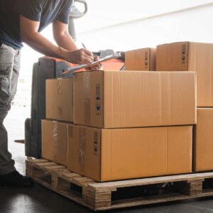 Warehouse-worker-holding-clipboard-doing-inventory-management-packaging-boxes.-Checking-stock.-Shipment-boxes.-Shipping-warehouse-logistics
