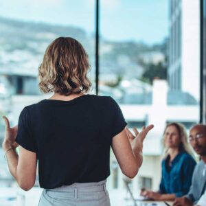 Female business leader conducting a meeting; female leader giving a presentation to colleagues